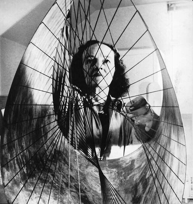 A view of a Barbara Hepworth sculpture with the artist behind it