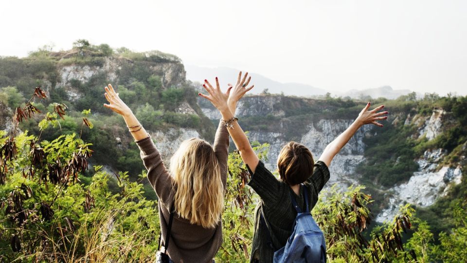 Photograph of two women throwing their arms in the air