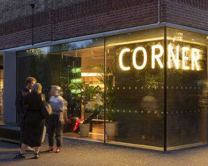 People standing in front a Corner sign